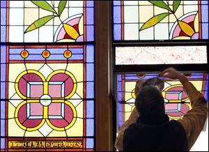 Rich Welsh dusts a stained-glass window at St. Rose Catholic Church. The biggest cleanup job was wiping off a thin layer of fine powder that had settled over the walls, floors, statues, pews, and windows.