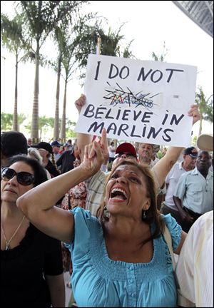 Protestor Olga Gomez gestures outside Marlins Stadium in Miami.