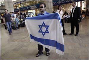 A demonstrator unfurls an Israeli flag in protest against a pro-Palestinian group expected to arrive at Ben Gurion Airport in Tel Aviv. The group planned to draw attention to Israeli travel restrictions on Palestinians.