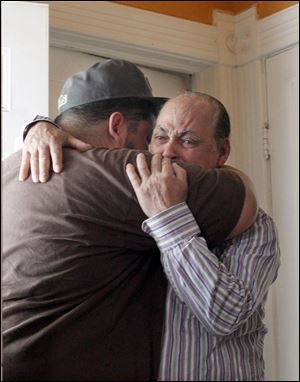 Santiago Izquierdo, right, whose son Raul, was killed Saturday night, receives a hug from his nephew Mario Ramos.