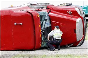 An overturned tractor trailer blocks the onramp to southbound I-75 in Perrysburg on Monday after a single vehicle accident. The two in the truck were taken to hospital with not life-threatening injuries, according to Perrysburg Police. Perrysburg Township Fire and EMS and Perrysburg also responded to the accident. 