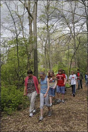 Montessori teacher Ruth Schroe-der, above left, leads students on the trail. At right in the foreground is Jessy Poiry, and directly behind her and Ms. Schroeder are fifth graders Laney Vander-hart and Megan Harvey. 