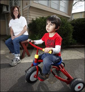 Amy Lingo, outside her Toledo home with son Jesse, 3, is in danger of losing her assistance. Ms. Lingo failed to meet work requirements after knee surgery. Her case is being reviewed. 