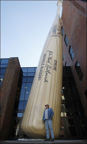 Bland McCall of Bennettsville, S.C., poses for a photograph in front of the iconic Louisville Slugger bat at the Louisville Slugger Museum & Factory in Louisville, Ky. 
