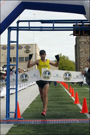Matt Folk finishes first in the Glass City Marathon on Sunday, becoming the first three-time winner in the 36-year history of the running event. His winning time was 2 hours, 26 minutes, 27 seconds.