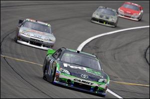Denny Hamlin (11) leads during the NASCAR Sprint Cup Series auto race at Kansas Speedway.