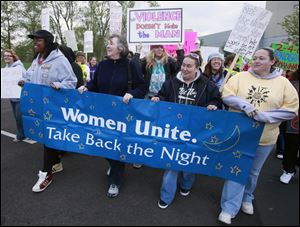 Brooke Day, Rose Mary Schaffer, Lisa Paul, and Suzanne Stuard, from left, lead the 18th annual Take Back the Night March on the Health Science Campus of the University of Toledo, formerly the Medical College of Ohio. The hour-long community rally Saturday featured music, poetry, and speakers addressing all forms of violence against women. A Resource Fair also was part of the observance. Thousands of marches and rallies bearing the name Take Back the  Night have taken
place worldwide.