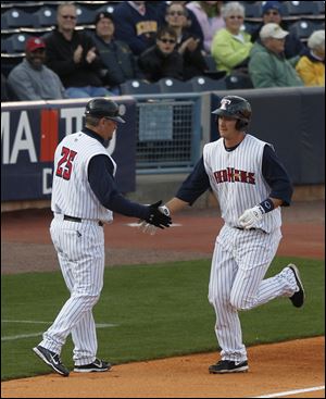Mud Hens manager Phil Nevin shakes hands with Ryan Strieby as he rounds 3rd base. Strieby hit a home-run in the 1st inning against Columbus at Fifth Third Field.