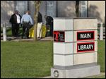  Police surround the bench outside the downtown library where the body of Susan Carter was discovered by a passer-by.