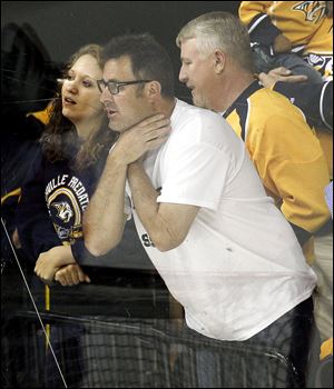 Country music star Vince Gill makes a choking gesture at Detroit Red Wings goalie Jimmy Howard after the Nashville Predators scored a goal in the third period of Game 2 of an NHL hockey Stanley Cup first-round playoff series April 13, in Nashville, Tenn. The Red Wings won 3-2.