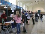  Teenagers speak to business representatives at the Erie Street Market. Saturday's youth job fair was the second this year.