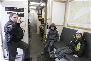 Lt. Tricia White of the Lucas County Sheriff's Office, left, explains some of the features of the department's communications van to Sam, 7, center, and Matt Mullins, 5, right, of Maumee. 