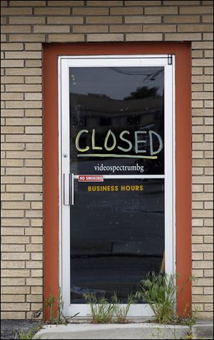 A sign on the door to Video Spectrum in Bowling Green informs customers they are closed.