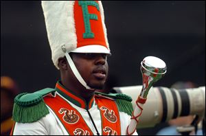 Robert Champion, a drum major in Florida A&M University's Marching 100 band, performs during halftime of a football game in Orlando, Fla. Thirteen people face criminal charges in the hazing death Champion aboard a band bus in Orlando last fall.