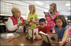 Barb Burnett works on reading with her fourth-grade students from left, Hailey Olson, Santiago Castro, Annabella Rodzos, and Michelle Huynh at Frank Elementary School in Perrysburg. Mrs. Burnett taught fifth grade before she retired in June, 2010.