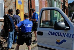 Two members of the Cincinnati Police Safe Streets Task Force question two men who emerged from a vacant building in the Over-the-Rhine neighborhood.