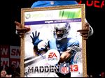  Lions wide receiver Calvin Johnson holds a large print of the cover of the Madden NFL 13 video game. The honor seems to bring some bad luck with it.