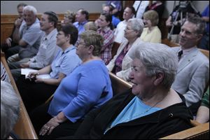 Seneca County Courthouse supporter Loretta Miller, right, laughs while watching the live play Market and Washington: Tiffin In Its Own Words,  during a Tiffin city council meeting at the Tiffin Municipal Building in Tiffin, Ohio. Eight actors from Heidelberg University put on the play.