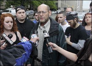 James Stevens, center, the father of accused plotter Connor C. Stevens, talks to the media outside Federal Court in Cleveland. At left is his daughter Brelin Stevens.