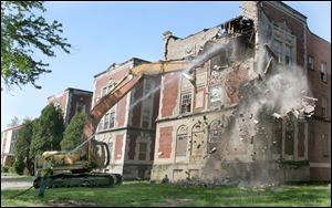 Collingwood Arms and Collingwood Manor apartments are in the process of being demolished. After decades of abandonment, two Depression-era apartment complexes in Toledo's Old West End began to crumble Tuesday as crews tore into the three-story brick-and-concrete buildings.