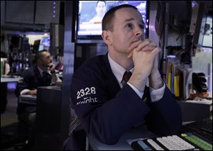Specialists Chris Gildea, left, and Stephen Naughton work on the floor of the New York Stock Exchange today. Political uncertainty in debt-hobbled Europe spread to financial markets Tuesday and pushed stocks sharply lower in Europe and the United States. 