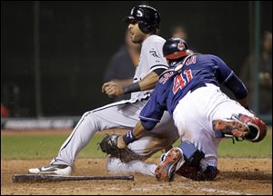 Chicago's Alex Rios slides safely into home ahead of a tag by catcher Carlos Santana in the 10th inning. Rios hit what proved to be the game-winning triple to score pinch runner Brent Lillibridge.