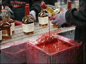 A bottle of Maker's Mark bourbon is dipped in red wax during a tour of the distillery in Loretto, Ky. The 6th U.S. Circuit Court of Appeals court says a liquor bottle with a red dripping wax seal by any name other than Maker's Mark would be illegal.