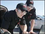  Whitmer High School seniors Josiah Meiring, left, and Mike Stockdale II consult an online serice manual while diagnosing trouble with a new Ford Fusion during the Ford-AAA Auto Skills State Competition.
