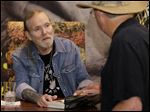  Gregg Allman, left, founding member of The Allman Brothers Band, talks with a fan as he signs copies of his autobiography 