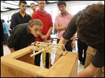  Giovanni Gardull, a Waite High School senior, watches for signs of structural failure as sand is added to a pail suspended from the bridge that he made of toothpicks and white glue. He was part of an engineering contest at the school.