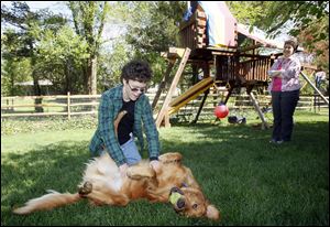 Michelle Self watches her son Alex Bentley play with Hamden, his therapy dog. Ms. Self is a member of the board of trustees of the Williams Syndrome Association.