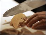  A chef prepares to slice a portion of foie gras, a fatty duck
liver delicacy.