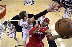 Los Angeles Clippers' Kenyon Martin, right, is defended by San Antonio Spurs' Tiago Splitter, left, as he drives to the basket during the first half of Game 2.