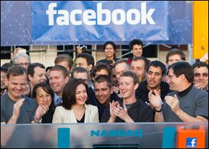 Facebook founder, Chairman and CEO Mark Zuckerberg, center, applauds at the opening bell of the Nasdaq stock market from Facebook headquarters in Menlo Park, Calif.