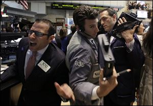 Traders work on the floor of the New York Stock Exchange during Thursday's session. Stocks slipped in early activity as discouraging economic reports further unnerved traders already concerned about a possible exit from the euro by Greece. The Dow lost 156.06 points, most toward the day's end.
