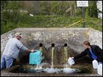  Danny and RaeJean Cantrell fill jugs with water from Buchtel Spring in Buchtel, Ohio. The couple have been using spring water for washing dishes and flushing the toilet since the tap water was turned off at their home.