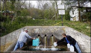 Danny and RaeJean Cantrell fill jugs with water from Buchtel Spring in Buchtel, Ohio. The couple have been using spring water for washing dishes and flushing the toilet since the tap water was turned off at their home.