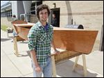  Aaron Zimmerman shows off the 13-foot mahogany boat that he built as the final project for his cabinetry class at Bedford Senior High School.