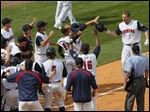  Brad Eldred is greeted by teammates as he comes home after hitting a two-out, three-run home run in the bottom of the ninth inning to lift the Mud Hens to a victory Sunday over Syracuse.
