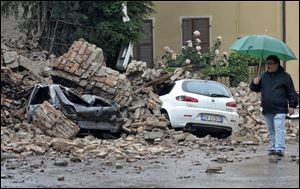 A man looks at the damage caused by a quake in Finale Emilia northern Italy, Sunday.