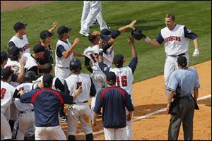 Brad Eldred is greeted by teammates as he comes home after hitting a two-out, three-run home run in the bottom of the ninth inning to lift the Mud Hens to a victory Sunday over Syracuse.
