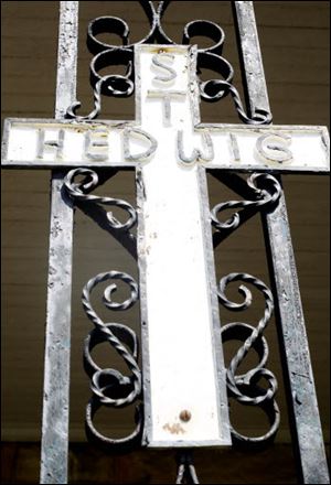 A cross hangs on the rectory of St. Hedwig which is closing on September 1.