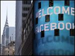  The Chrysler Building is visible behind the animated facade of the Nasdaq MarketSite, welcoming the Facebook IPO, in New York last Friday.