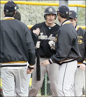 Perrysburg High School's designated hitter Hunter Smith, center, is congratulated by his teammates at home plate after hitting a home run.