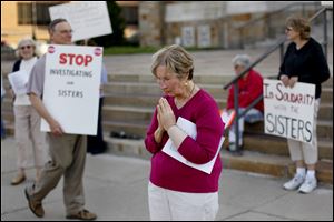 Pat Hanusz, of Corpus Christi University Church, prays in front of Rosary Cathedral on Tuesday in support of Catholic nuns.  Hanusz said, 