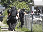  CTY swat24p  Members of the Toledo Police Department SWAT move into a home after a shooting on Bricker near Doyle, May 23, 2012. The Blade/Andy Morrison