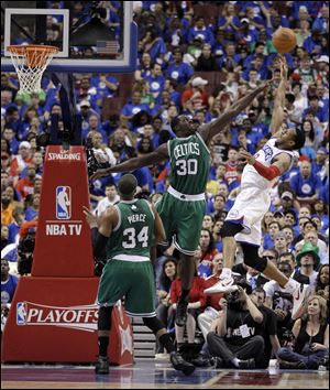 Philadelphia 76ers' Andre Iguodala, right, goes up for a shot as Boston Celtics' Brandon Bass, center, and Paul Pierce defend during the first half of Game 6.