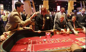 David Garewal of Cleveland rolls the dice as staff members practice at the Hollywood Casino in Toledo during a recent media tour of the facility.