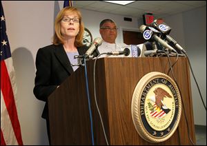 Carole Rendon, 1st Assistant U.S.Attorney, discusses the charges filed against 18 people stemming from raids last fall at a number of area IHOP restaurants, during a news conference at the U.S. Attorney's office in Toledo.  Deputy Toledo Police Chief George Taylor is at back right.  A majority of  the charges are for money laundering, harboring of illegal immigrants, and identity theft.