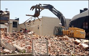 Demolition crews take down the former Bowling Green Junior High School Wednesday. The city plans to purchase the vacant lot from Midwest Environmental Control as a possible site for a new city hall once the school is gone.